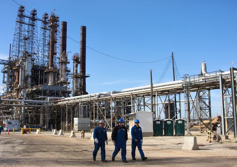 Refinery workers walk inside the LyondellBasell oil refinery in Houston, Texas March 6, 2013.