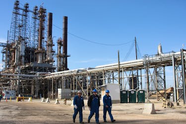 Refinery workers walk inside the LyondellBasell oil refinery in Houston, Texas March 6, 2013.