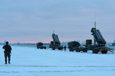 Serviceman patrols in front of the Patriot air defence system during Polish military training on the missile systems at the airport in Warsaw, Poland February 7, 2023.