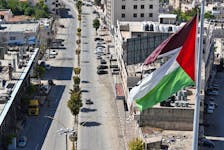 A Palestinian flag flies over empty streets during a general strike in Hebron, to mourn those killed in Tulkarm, in the Israeli-occupied West Bank, April 21, 2024.