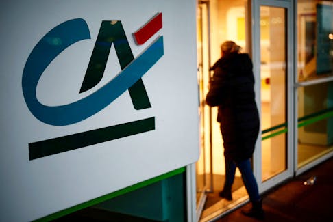A woman walks past a Credit Agricole logo as she enters a bank office in Reze, near Nantes, France, February 8, 2024. 