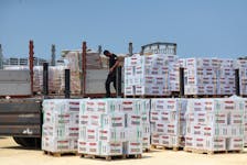 A worker unloads humanitarian aid, amid the ongoing conflict in Gaza between Israel and the Palestinian Islamist group Hamas, near the Erez Crossing point in northern Gaza, May 1, 2024.