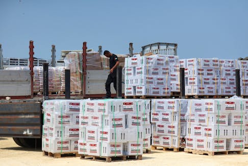 A worker unloads humanitarian aid, amid the ongoing conflict in Gaza between Israel and the Palestinian Islamist group Hamas, near the Erez Crossing point in northern Gaza, May 1, 2024.