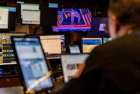 A trader works inside a booth, as screens display a news conference by Federal Reserve Board Chairman Jerome Powell following the Fed rate announcement, on the floor of the New York Stock Exchange (NYSE) in New York City, U.S., May 1, 2024.