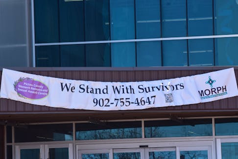 The Pictou County Women's Resource and Sexual Assault Centre hung a banner from the entrance of the Pictou County Wellness Centre, the banner reads "We Stand With Survivors" along with the phone number for the Women's Centre and a QR code that when scanned takes people to the center's website with available resources. -Sarah Jordan
