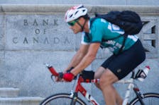 A cyclist rides past the Bank of Canada building, Ontario, Canada, July 11, 2018.