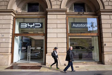 People walk in front of BYD Auto company and Autotorino store in Milan, Italy, March 20, 2024.