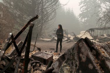 Hansel Valentine, 24, inspect the remains of the burnt down property of her relatives, as the wildfire continues in Estacada, Oregon, U.S., September 13, 2020.