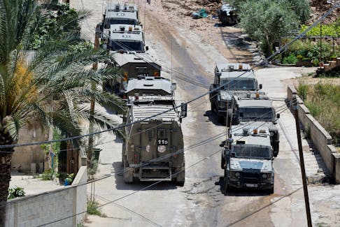 Israeli military vehicles are seen during an Israeli raid in Deir al-Ghusun, in the Israeli occupied West Bank, May 4, 2024.