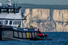 A British Border Force vessel picks up an inflatable dinghy carrying migrants in front of the white cliffs of Dover in the English Channel, Britain, May 4, 2024.