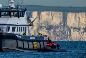 A British Border Force vessel picks up an inflatable dinghy carrying migrants in front of the white cliffs of Dover in the English Channel, Britain, May 4, 2024.