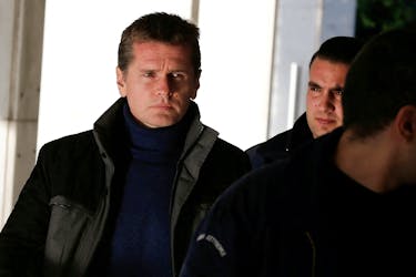 Alexander Vinnik, a 38 year old Russian man suspected of running a money laundering operation using bitcoin, is escorted by police officers to a court in Athens, Greece December 13, 2017.