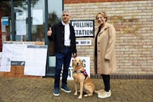 Mayor of London Sadiq Khan and his wife Saadiya react standing with their dog Luna outside a polling station during local elections in London, Britain May 2, 2024.