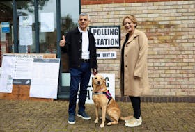 Mayor of London Sadiq Khan and his wife Saadiya react standing with their dog Luna outside a polling station during local elections in London, Britain May 2, 2024.