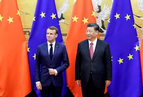 Chinese President Xi Jinping and French President Emmanuel Macron stand in front of Chinese and EU flags at a signing ceremony inside the Great Hall of the People in Beijing, China November 6, 2019. 