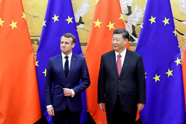 Chinese President Xi Jinping and French President Emmanuel Macron stand in front of Chinese and EU flags at a signing ceremony inside the Great Hall of the People in Beijing, China November 6, 2019. 