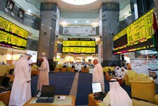 Investors monitor screens displaying stock information at the Abu Dhabi Securities Exchange June 25, 2014.