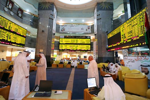 Investors monitor screens displaying stock information at the Abu Dhabi Securities Exchange June 25, 2014.