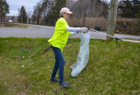 Ann Dunn-Ling reaches for a piece of trash while cleaning litter from a ditch near Malcolm Munroe Memorial Middle School in Sydney River during the CBRM's Cape Breton Clean Up on Saturday. The Sydneya River resident has been volunteering with the annual cleanup since it began more than 10 years ago. Dunn-Ling says she thinks the litter problem has gotten worse. "That's why I do it," she said. "It's the beginning of tourist season and we live here. We should all have a beautiful area." More than 300 community members took part in Saturday's cleanup event, around the CBRM, according to the municipality's Facebook page. NICOLE SULLIVAN/CAPE BRETON POST