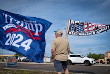 A supporter of Republican presidential candidate and former U.S. President Donald Trump waves a flag during a gathering in Palm Harbor, Florida, U.S. March 10, 2024.