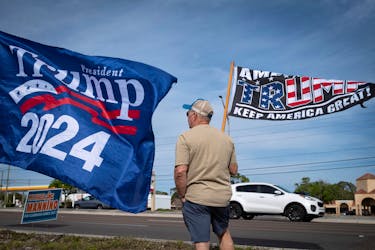 A supporter of Republican presidential candidate and former U.S. President Donald Trump waves a flag during a gathering in Palm Harbor, Florida, U.S. March 10, 2024.