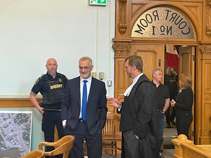 Lawyer Robert Regular (second from left), who is facing charges of sexual assault and sexual interference, speaks with his lawyer, Jerome Kennedy Thursday in court in St. John's. Evan Careen • The Telegram