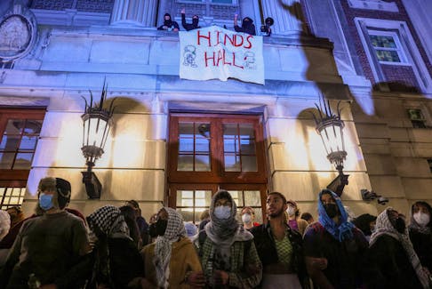 Protesters link arms outside Hamilton Hall barricading students inside the building at Columbia University, despite an order to disband the protest encampment supporting Palestinians or face suspension, during the ongoing conflict between Israel and the Palestinian Islamist group Hamas, in New York City, U.S., April 30, 2024.