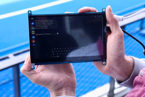 A cybersecurity employee from the Paris 2024 flying squad uses a tablet to test the cybersecurity rules on the Olympic site which will host the hockey events at Yves-du-Manoir Stadium in Colombes, near Paris, France, May 3, 2024.