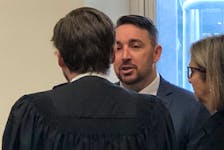 Doug Snelgrove speaks with his lawyer Owen Goddard during a break in proceedings at the Newfoundland and Labrador Court of Appeal Thursday, Nov. 4, 2022. Snelgrove, a Royal Newfoundland Constbulary officer, is appealing his conviction for sexually assaulting a woman while on duty in 2014.