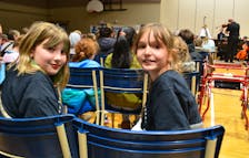 Grade 4 Greenfield Elementary School students Ally MacDonald, left, and Cali Fraser wait for the start of a Music Monday concert at Shipyard Elementary School in Sydney on Monday. Three concerts were done which featured the Cape Breton Orchestra and Mi'kmaq artists. NICOLE SULLIVAN/CAPE BRETON POST