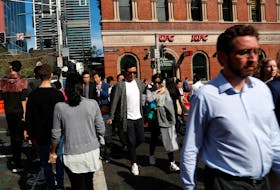 People cross a street in Sydney, Australia May 8, 2018.