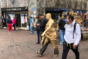 A man covered in gold paint walks in a pedestrian area in downtown Santiago, Chile, February 16, 2021.