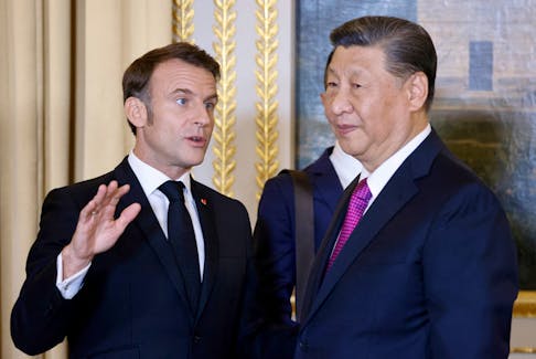 French President Emmanuel Macron and Chinese President Xi Jinping speak as they attend an official state dinner as part of the Chinese president's two-day state visit to France, at the Elysee Palace in Paris, France, May 6, 2024.  Ludovic Marin/Pool via