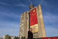 A woman passes by a Chinese flag hanging from a building ahead of President Xi Jinping's visit in Belgrade, Serbia, May 6, 2024.