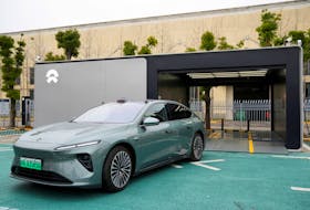 A staff member of Chinese electric vehicle (EV) maker Nio drives a Nio car as he demonstrates to media about the operation of the new battery swapping station, at a delivery center of the company, in Nanxiang, Shanghai, China March 23, 2023.