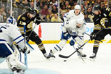 May 4, 2024; Boston, Massachusetts, USA; Boston Bruins defenseman Charlie McAvoy (73) tries to control the puck while Toronto Maple Leafs defenseman Simon Benoit (2) defends during the third period in game seven of the first round of the 2024 Stanley Cup Playoffs at TD Garden. Mandatory Credit: Bob DeChiara-USA TODAY Sports/File Photo