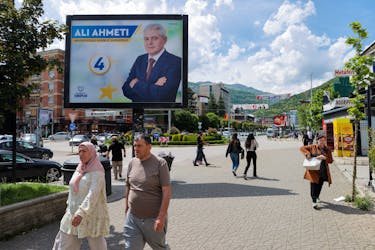 Pedestrians walk past campaign billboards for the upcoming parliamentary and presidential elections in Tetovo, North Macedonia May 7, 2024.