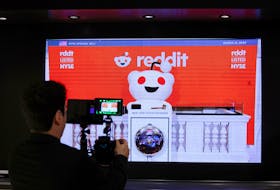 A person records the Reddit mascot as it rings the opening bell, at the New York Stock Exchange (NYSE) in New York City, U.S., March 21, 2024.