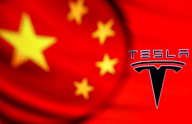 Chinese flag and Tesla logo is seen through a magnifier in this illustration taken January 7, 2021.