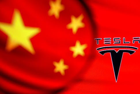 Chinese flag and Tesla logo is seen through a magnifier in this illustration taken January 7, 2021.