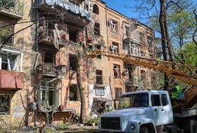 Communal workers work at a site near an apartment building damaged by a Russian air strike, amid Russia's attack on Ukraine, in Kharkiv, Ukraine May 5, 2024.