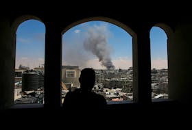 A Palestinian man watches as smoke rises after Israeli strikes while Israeli forces launch a ground and air operation in the eastern part of Rafah, amid the ongoing conflict between Israel and Hamas, in Rafah, in the southern Gaza Strip May 7, 2024.