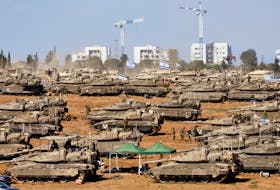 Israeli soldiers stand next to military vehicles, amid the ongoing conflict between Israel and the Palestinian Islamist group Hamas, near the Israel-Gaza Border, in southern Israel, May 7, 2024.