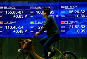 A man rides a bicycle past an electronic screen displaying the current Japanese Yen exchange rate against the U.S. dollar and other foreign currencies in Tokyo, Japan May 2, 2024,