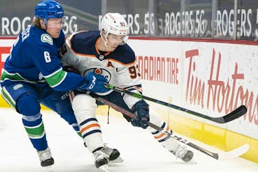 Brock Boeser (No. 6) of the Vancouver Canucks attempts to check Ryan Nugent-Hopkins (No. 93) of the Edmonton Oilers away from the puck during the first period at Rogers Arena on May 3, 2021 in Vancouver.