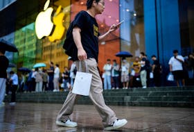 A man holds a bag with a new iPhone inside it in Shanghai, China September 22, 2023.