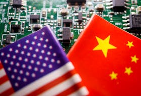 Flags of China and U.S. are displayed on a printed circuit board with semiconductor chips, in this illustration picture taken February 17, 2023.
