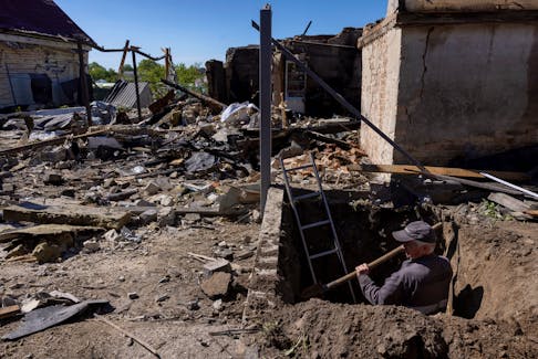 A worker digs to uncover a gas pipe leading to a house that was destroyed during a Russian missile strike, amid Russia’s attack on Ukraine, in Krasylivka, Kyiv region, Ukraine, May 8, 2024.