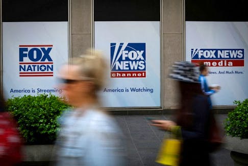 People walk past Fox News posters on the exterior of the News Corporation and Fox News headquarters building in Manhattan in New York City, New York, U.S., April 24, 2023.