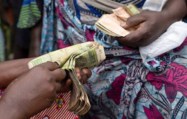 Clementine Musonge, a trader, counts Congolese francs bank notes at the Kituku market in Goma, North Kivu province of the Democratic Republic of Congo February 15, 2024.